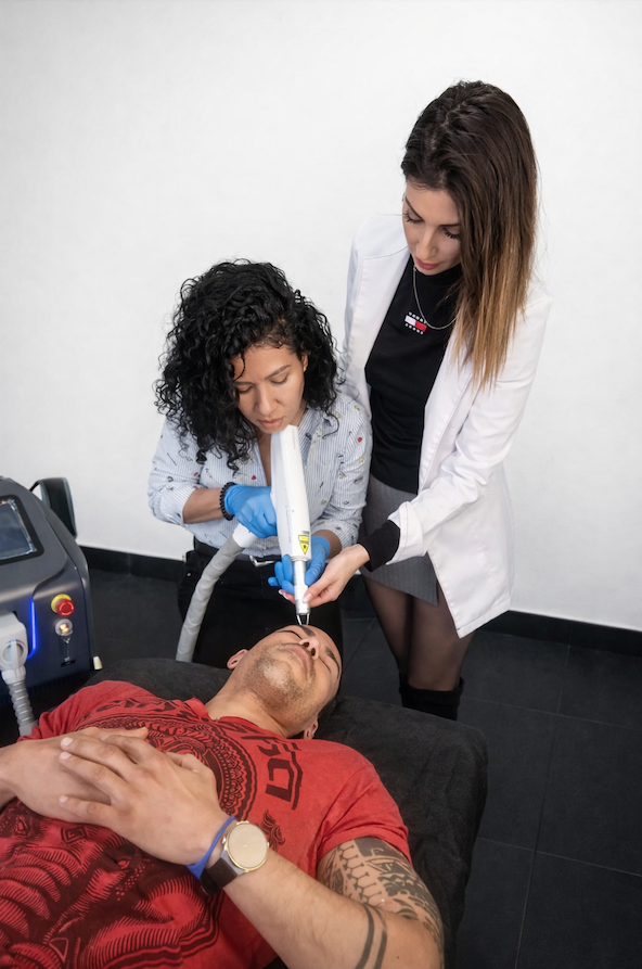 instructora realiza junto con una alumna una prácticas de eliminación de Micropigmentacion en Tattoo School Madrid